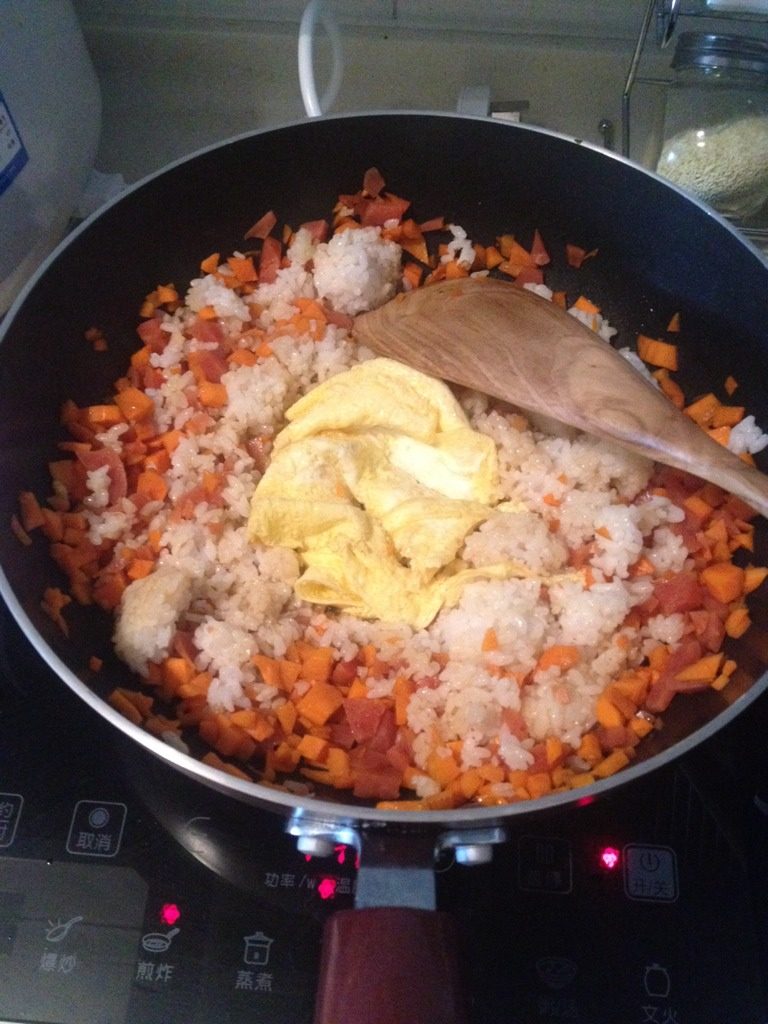 鸡蛋火腿炒饭,倒入米饭与鸡蛋，加入精盐翻炒