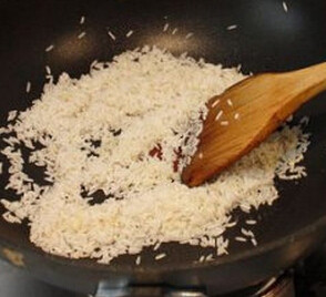 海南鸡饭,锅里放一些鸡汤，放入蒜茸炒香，再倒入清洁后的大米，翻炒均匀
