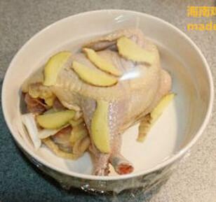海南鸡饭,将鸡放在大碗里，再铺上一些姜片，蒙上保鲜膜，入冰箱冷藏过夜