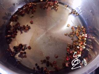 椒麻手撕鸡,麻椒粒和花椒粒放入油锅，烧至六成热