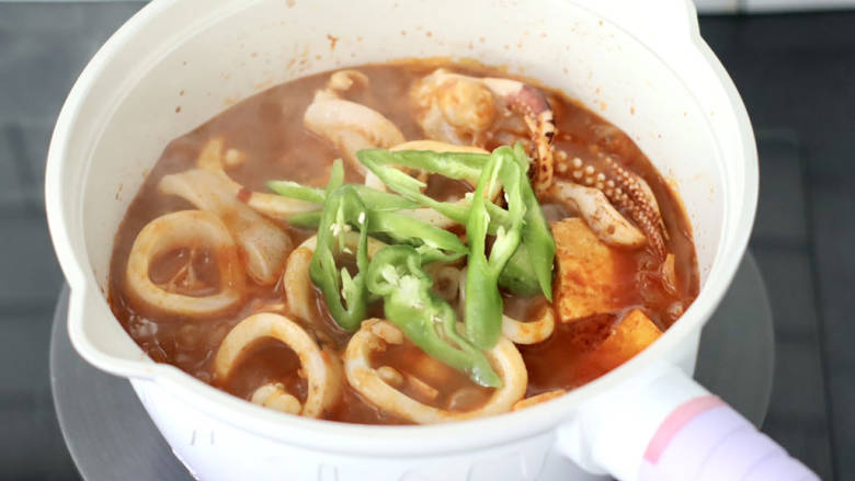 韩式泡菜鱿鱼豆腐煲,出锅前加入辣椒丝即可。