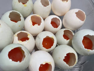五彩糯米蛋,一端敲破一个小口子，倒出蛋清，只留蛋黄。
