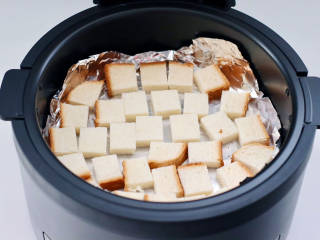 蒜香芝麻吐司酥,空气炸锅提前预热，铺上油纸，放入切好的吐司块。