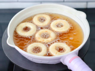 快手甜甜圈,锅中倒入适量油，烧至七成热，放入个小面团可以起泡飘上来的时候，把甜甜圈面胚放入油锅中。