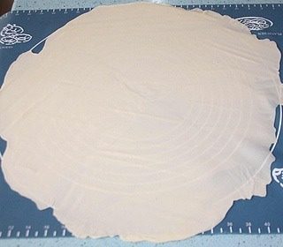 千层手抓饼,如图将面团分成2份（也可以根据喜欢分成多份），其中一份先用保鲜膜覆盖上，防止变干 ，案板或是硅胶垫上先抹些油，然后将小面团擀成一个薄薄的面饼，圆形或者方形都可。注意这里越薄越好。和我一样使用硅胶垫的tx，以能够透过面饼看到硅胶垫上的图案为好