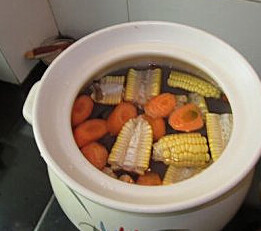 南北杏玉米煲沙骨,锅里放入猪骨，再加入玉米、南北杏，最后加入胡萝卜、姜片、蜜枣和3000ml的水