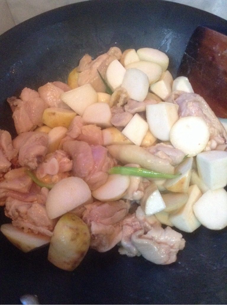 乳香琵琶腿芋艿煲,葱姜蒜炝锅，倒入炒好的芋头和鸡肉，继续翻炒。