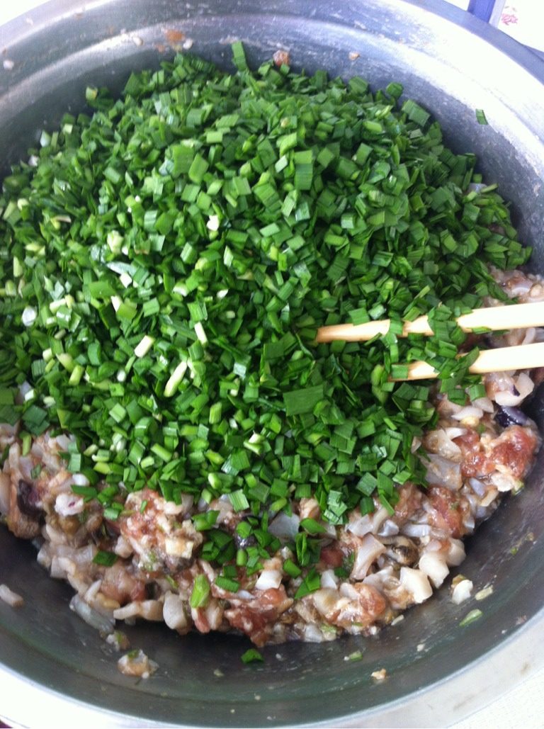 海螺馅饺子,如图 放入切好的韭菜末，倒入食用油搅匀。