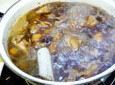 香菇栗子炖鸡,加入香菇，继续烧开锅，转小火，汤汁炖至鸡肉一半加入盐继续炖