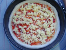 简易腊肠披萨 ,先涂抹一层番茄酱,再铺一层马苏里拉奶酪丝