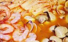 韩式泡菜海鲜锅,依次加入金针菇、蛤蜊、基围虾炖煮，至入味