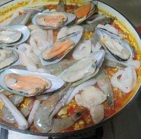 西班牙海鲜饭,开锅后转小火，待锅中的汤汁快要收干，放入海鲜