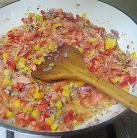 西班牙海鲜饭,放入欧芹翻炒出香味，放入彩椒丁和番茄翻炒均匀
