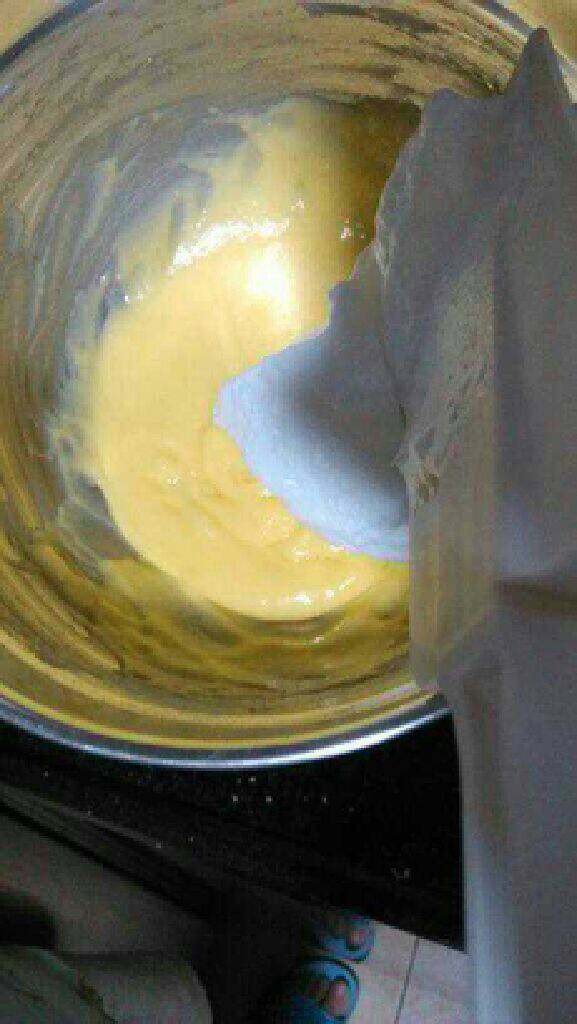 自制芒果慕斯蛋糕,将3/1的蛋白加入蛋黄糊里继续搅拌均匀。