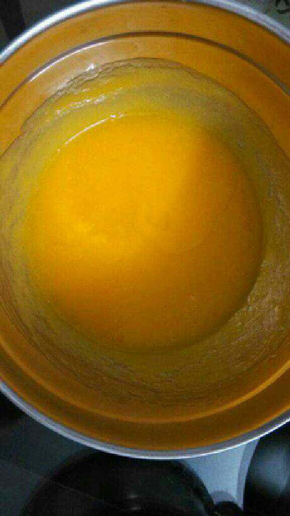 自制芒果慕斯蛋糕,嗝化的吉利丁片倒入芒果酱中，嗝冷水搅拌至浓稠的酱状。