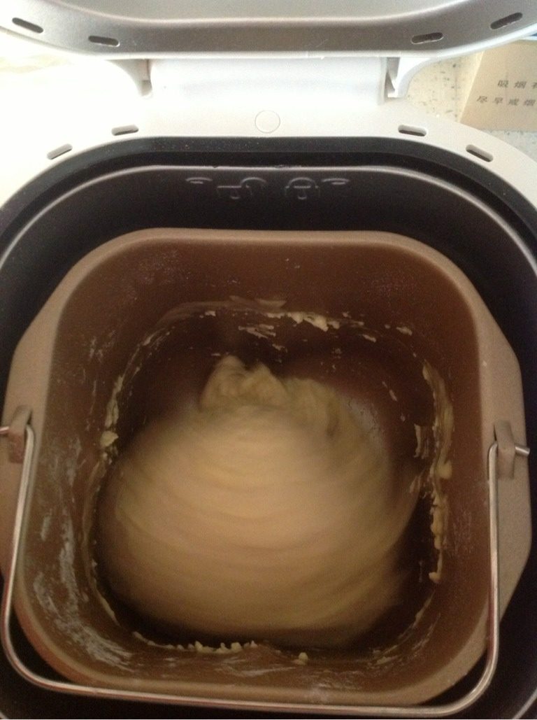 松软面包（面包机版）,面团取出排气，赶成牛舌状，在卷成卷，放进面包桶进行二次发酵。