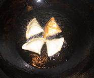 咖喱炸三角,把生坯下入旺油锅内，用中火炸熟，呈深黄色，捞出即可