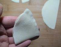 咖喱炸三角,将半圆形饼对折成扇形，把直边捏紧。