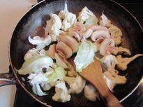 法式奶油菜花汤,先下入洋葱和蒜片煸炒， 再放入花菜和口蘑一起翻炒