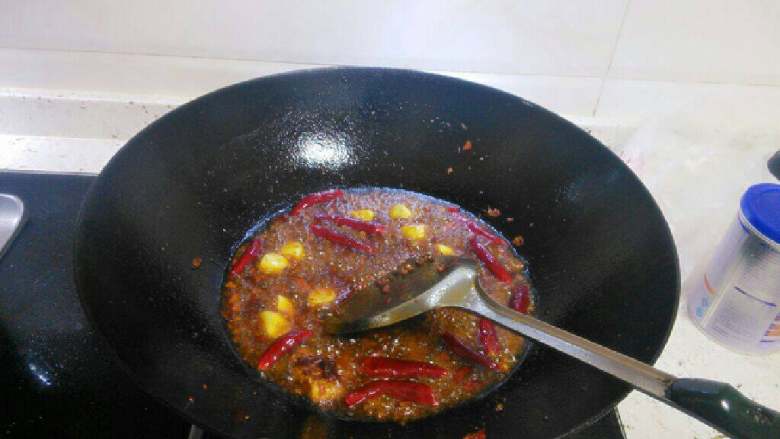 火锅鱼,改大火放入姜蒜块和干辣椒翻炒，最后放入干花椒爆香。