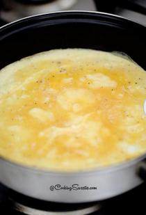 豌豆奶酪西式蛋饼,在平底煎锅中加入黄油软化，倒入鸡蛋汁摊成蛋饼移至盘中
