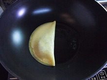 苹果鸡蛋饼,用锅铲把整张蛋皮对半对折，再轻轻把边缘压紧。
