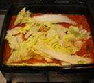 韩风辣味豚肉锅,大火煮开后，下入部分白菜叶，煮至菜叶变软