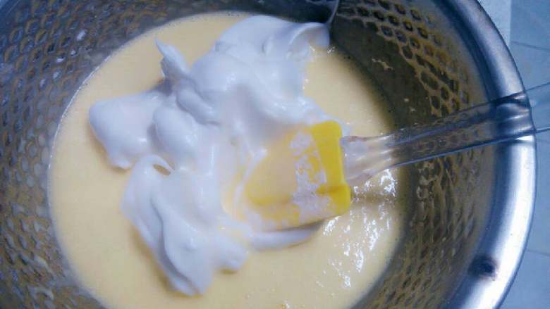 酸奶蛋糕,将三分之一的打发蛋白加入调好的蛋糊盆中，上下翻动均匀混合。
