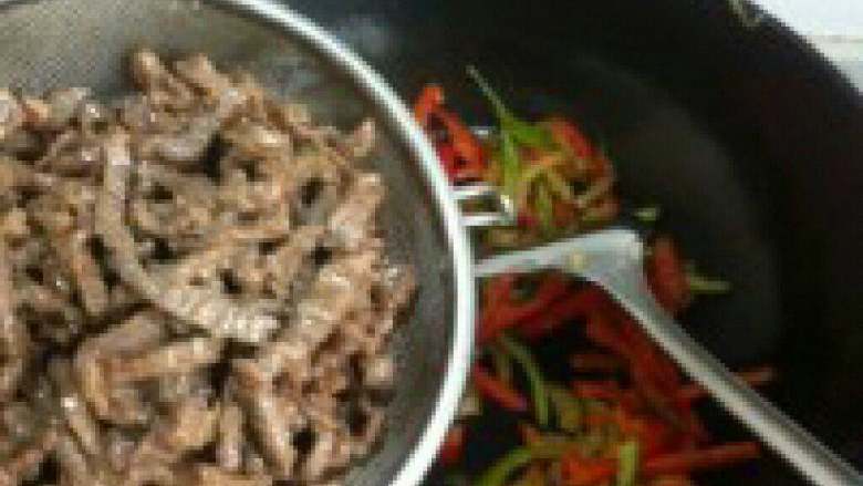 牛肉辣椒汤米粉,锅里放油在放入青红辣椒，在放入炒好的牛肉一起爆炒。