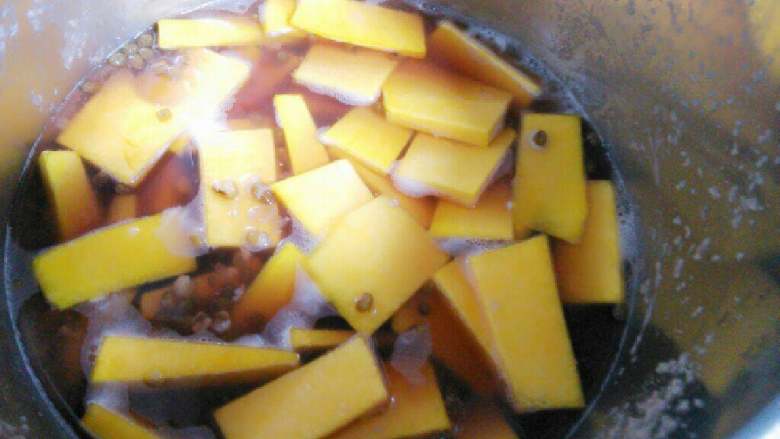 绿豆南瓜煲,将南瓜块下入锅内，盖上盖，用小火煮约3至南瓜变软。