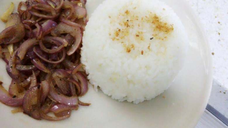 猪排饭,盘里准备好米饭（可洒些芝麻做装饰），将黑胡椒洋葱摆在饭旁边。