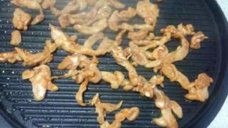 鸡肉卷饼,饼档热后刷一点油把鸡肉到在上面炒熟后盛出来备用。