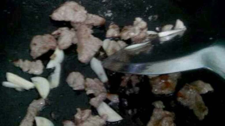 香菇炒肉,放入蒜爆香在放腌制好的肉进去炒。