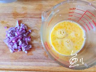 玉米虾仁蛋炒饭,紫洋葱切碎，鸡蛋打入碗中搅散