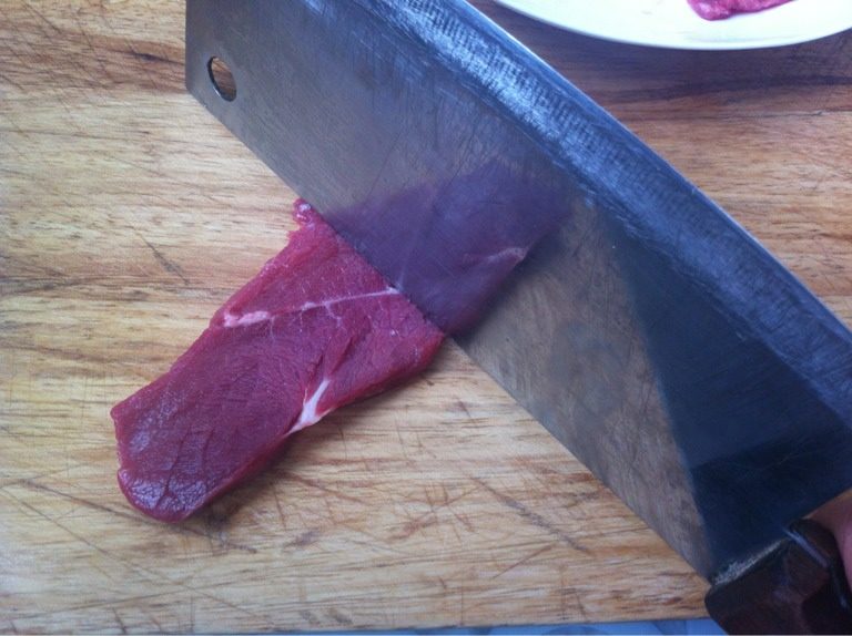 炸牛排,如图 牛肉切大片，大约5、6毫米厚。用刀背轻剁一会儿。