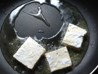 茄汁豆腐,锅中放油至7成熟时，将豆腐片放入锅里煎