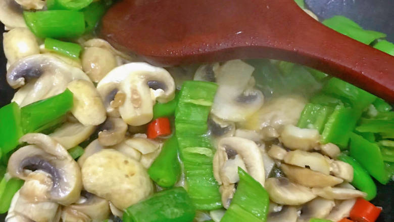 素炒双丁,将鲜蘑菇和青辣椒翻炒均匀