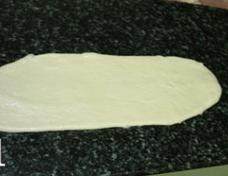 法式培根麦穗包 ,松弛好的面团擀成长条形，翻面