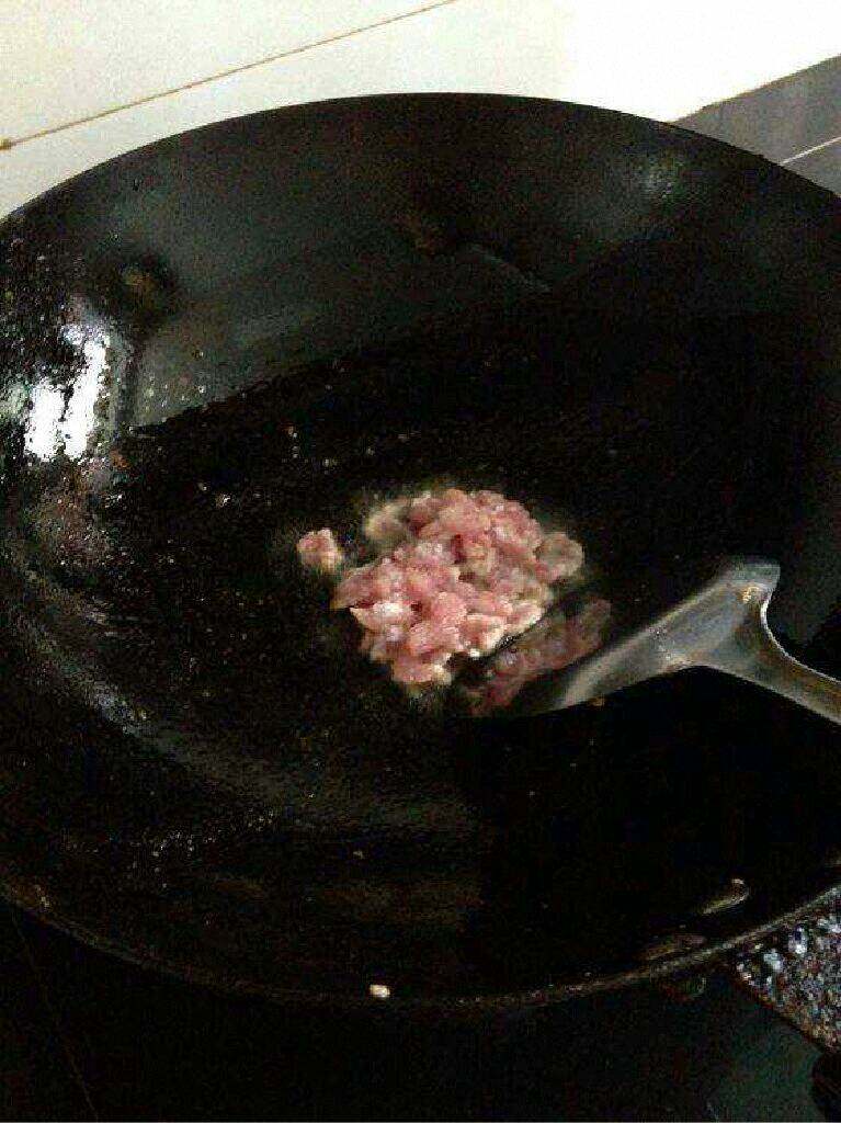 豆腐干炒肉,锅里放油在把肉倒进去翻炒。