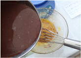 巧克力乳酪慕斯-慕斯做法,把加热好的巧克力乳酪液一点一点倒入蛋黄中。