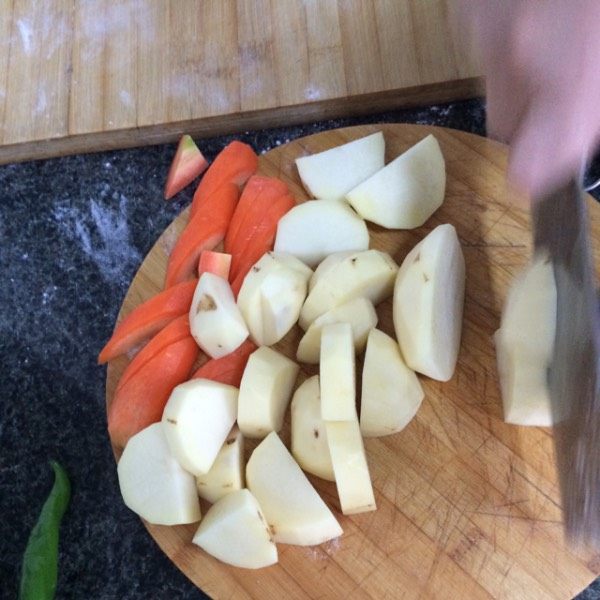羊肉焖饼子,饼子好了以后，将胡萝卜和土豆切成滚刀块，不能太小，将切好的胡萝卜和土豆放到肉里，翻炒几下。