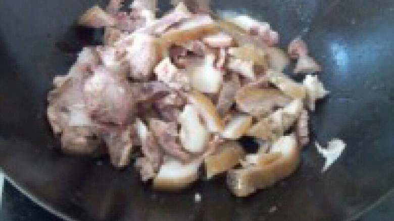 胡萝卜炒猪头肉,锅里放油把肉放进去去炒。