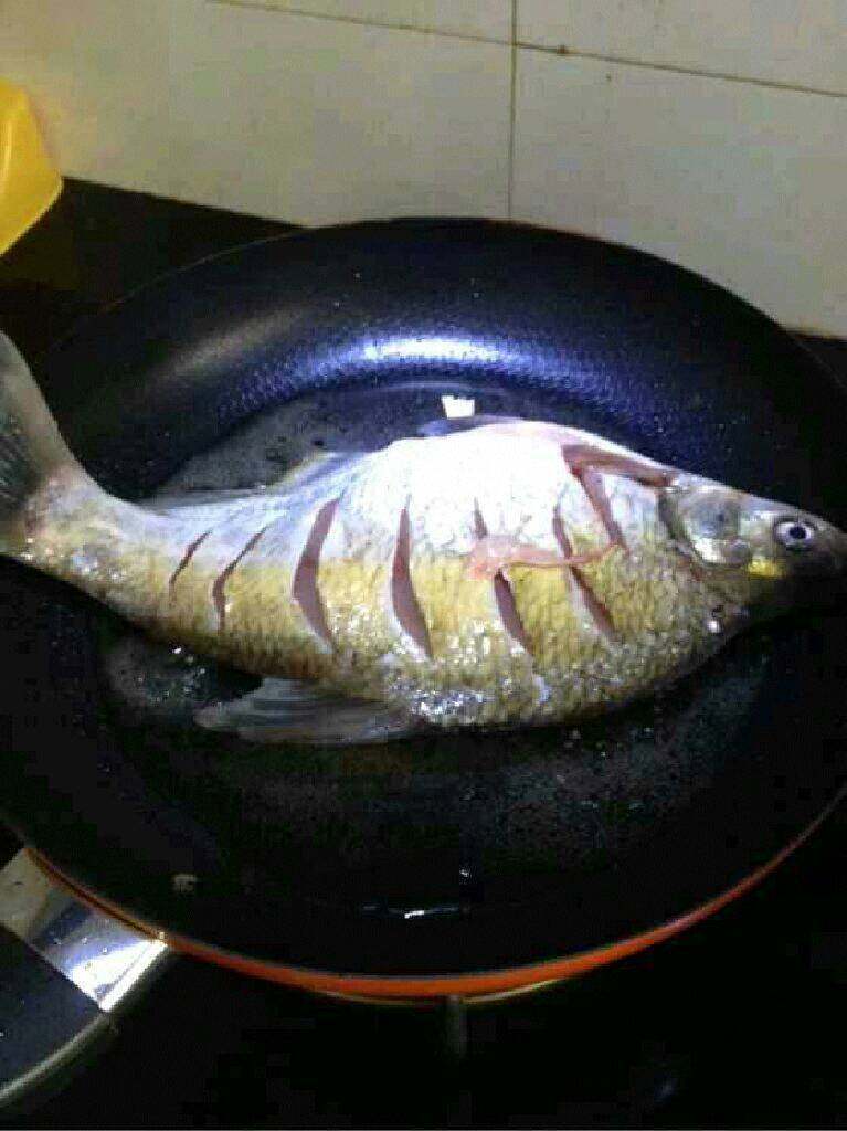 红烧鳊鱼,锅里放油把鱼放进去炸。