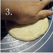 红豆面包,用手将面团按压排气，用擀面杖擀成圆饼形；