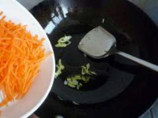 胡萝卜丝炒鸡蛋,锅里放油把葱白放进去爆香，在把胡萝卜倒进去翻炒。