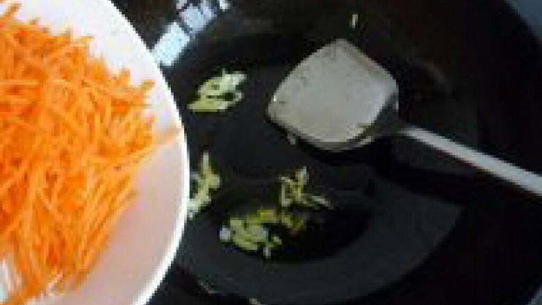 胡萝卜丝炒鸡蛋,锅里放油把葱白放进去爆香，在把胡萝卜倒进去翻炒。