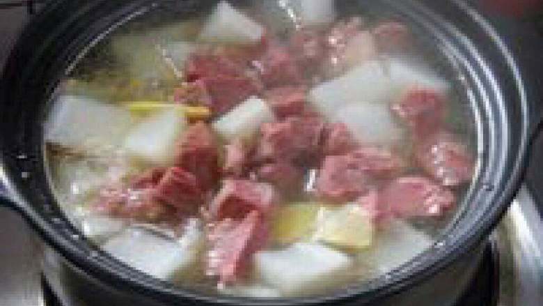 白萝卜煲牛肉汤,打开盖子放入适量盐调味。
