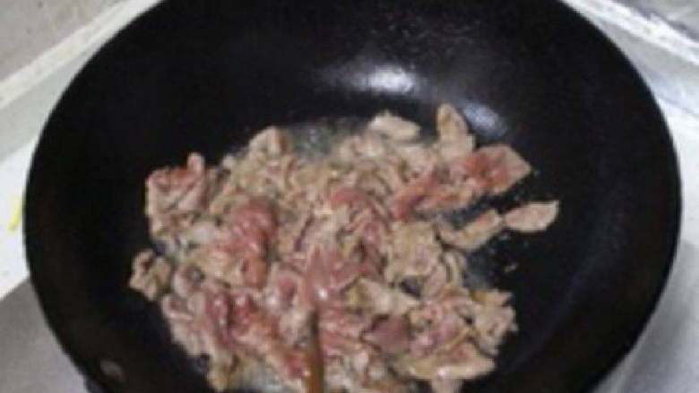 葱爆羊肉,上锅烧油，5成热的时候将腌制好的羊腿肉下锅，翻炒泛白之后就盛出。