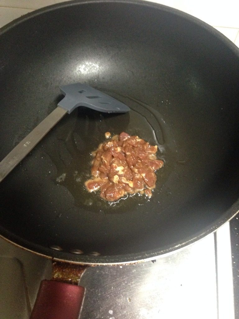 青椒萝卜炒豆干肉丝,如图起锅把腌好的猪肉丝爆炒，爆炒至微焦，加入少量水。装盘待用。