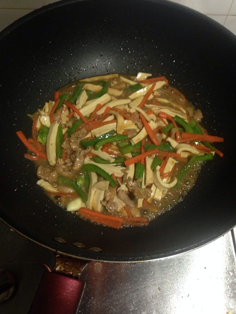 青椒萝卜炒豆干肉丝,如图倒入猪肉丝，加入适量的水，盖上锅盖。三分钟。